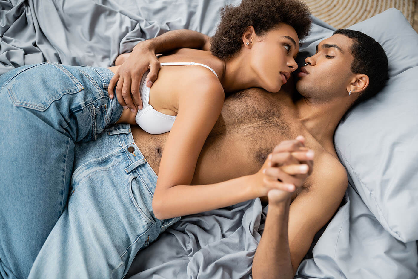 Sex-ohne-Orgasmus-Ein-Paar-liegt-im-Bett-und-haelt-Haendchen