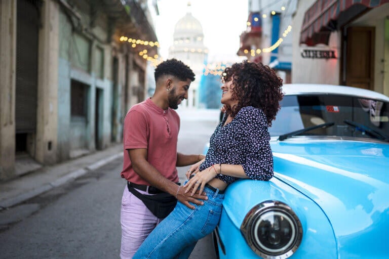 Glueckliches-Paar-steht-am-Auto-weibliche-Lust-abhaengig-von-Beziehungsglueck-Studie